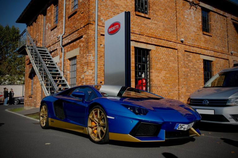 blue lamborghini parked near brown brick building