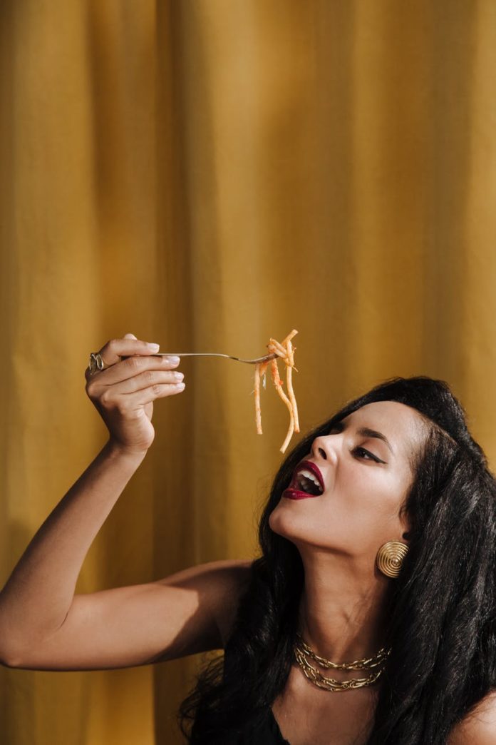 woman eating forkful of pasta