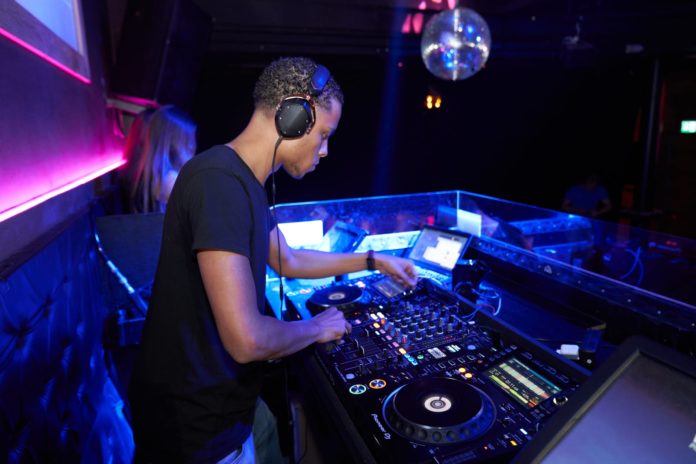 man wearing black crew neck shirt playing dj turntable